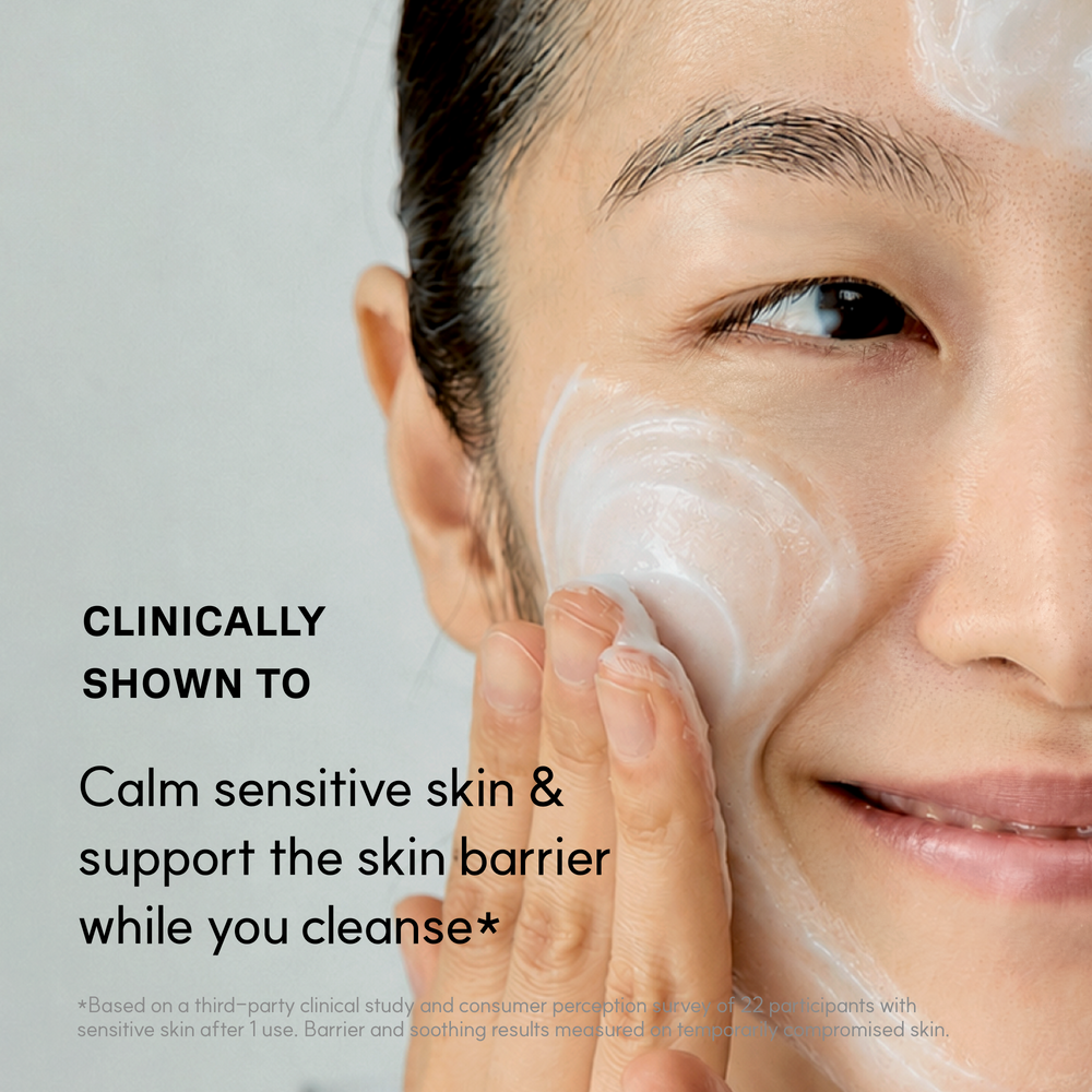 Woman massaging Blue Calming Cleansing Milk onto her cheek, clinically shown to calm sensitive skin and support the skin barrier