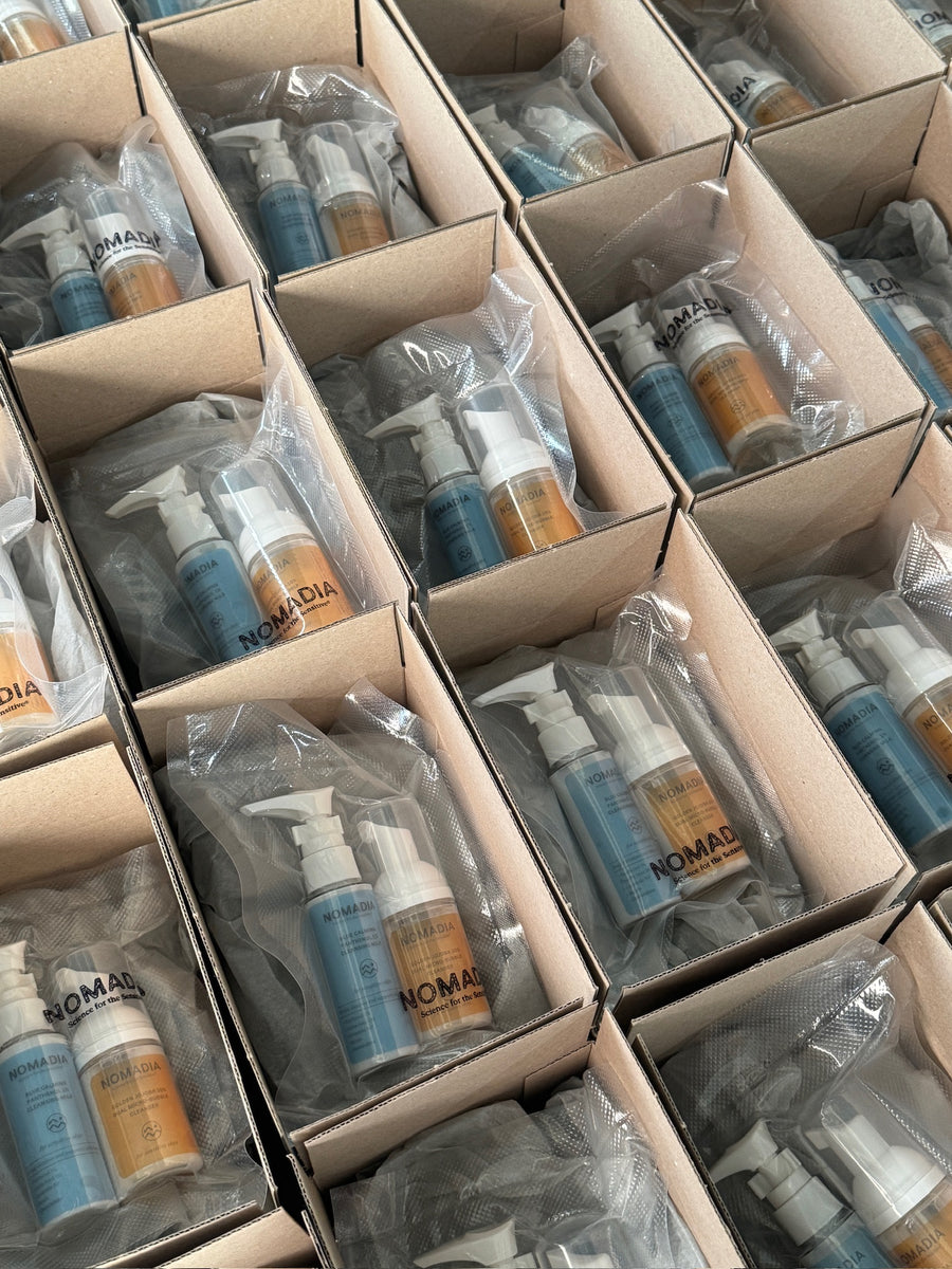 Limpiadores azul y dorado de NOMADIA empaquetados en cajas de cartón abiertas