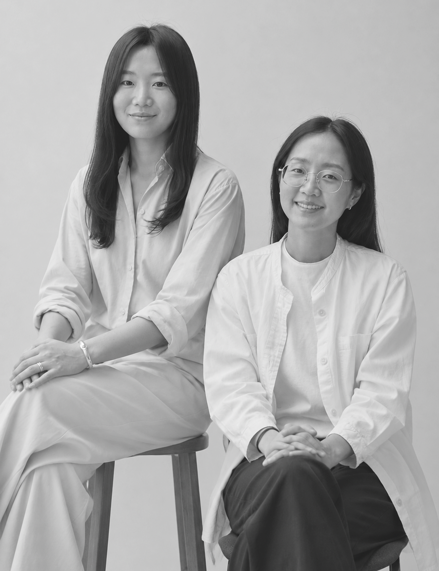 Retrato en blanco y negro de dos integrantes del equipo de NOMADIA sentadas una junto a la otra